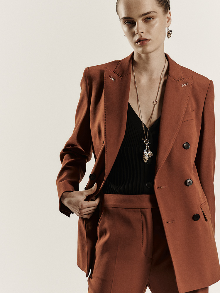 Model wears Max Mara Sartoriale double-breasted blazer in rust-colour wool granite, with contrasting black top.